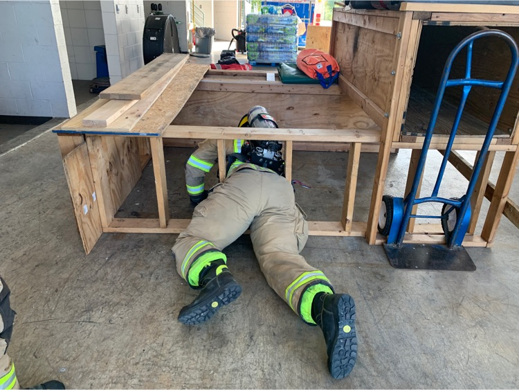 Firefighter going thru a confined space workout station