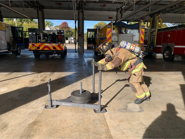 firefighter pushing weighted sled